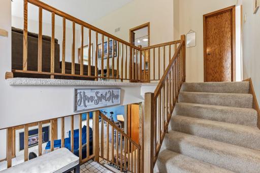 Welcoming split-level entry featuring neutral dÃ©cor and classic oak railings. The open foyer design provides easy access to both levels, creating a bright and airy feel.