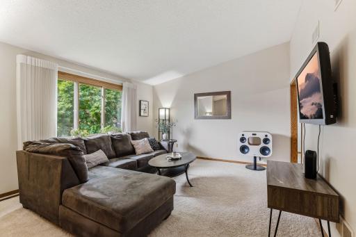 Neutral tones, plush carpeting, and an open layout create a warm and inviting atmosphere.