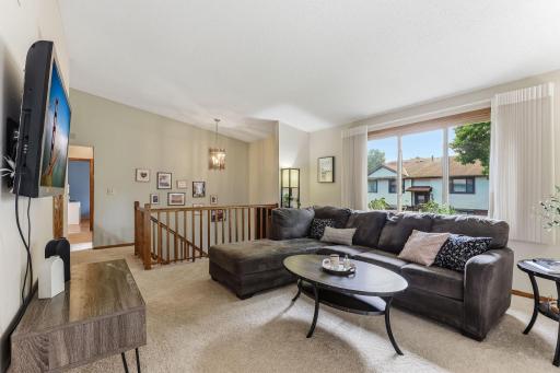 Open to the foyer below, the layout feels bright and connected while offering ample room for seating and everyday living.