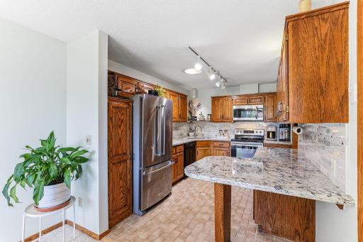 Kitchen featuring Cambria quartz countertops, stainless steel appliances, and abundant oak cabinetry.