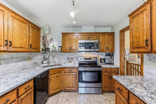 In addition to the kitchen's Cambria quartz countertops and stainless steel appliances, a decorative tile backsplash adds texture and style to the space.