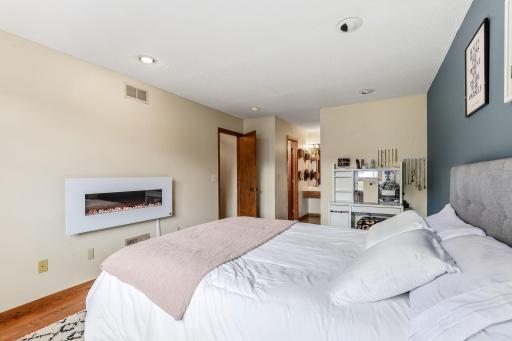 Primary bedroom with recessed lighting, an electric fireplace (included), and a private vanity.