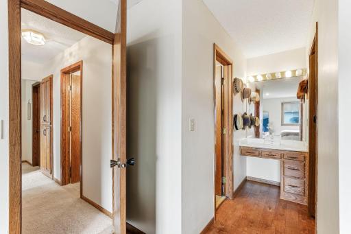 Primary suite vanity area with hardwood flooring, ample counter space, and built-in storage.