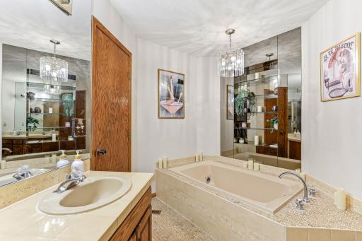Mirrored accents and built-in display shelving add character, creating a spacious and functional owner's retreat.