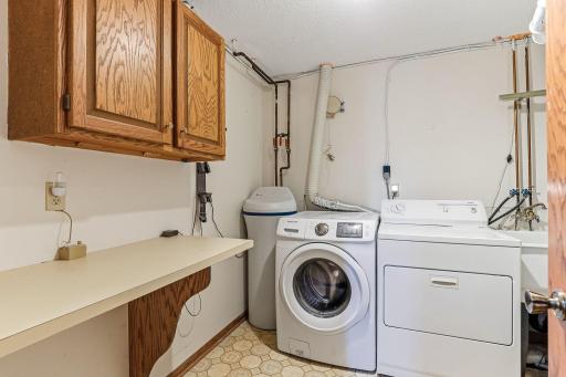 Laundry/utility room with built-in cabinetry and countertop workspace for folding, sorting, and storage.