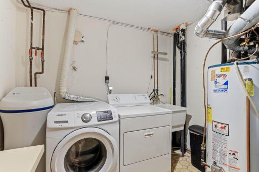 Laundry and utility room with washer and dryer, utility sink, and space for storage.