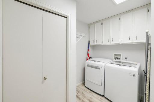 Main floor laundry room with large coat closet and cabinets for extra storage