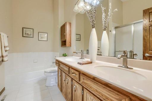 Primary bedroom bathroom with dual vanities, tub and separate shower.