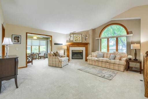 Main floor living room with tons of natural light, gas fireplace and high ceilings. Cute sun room adjacent to living room.