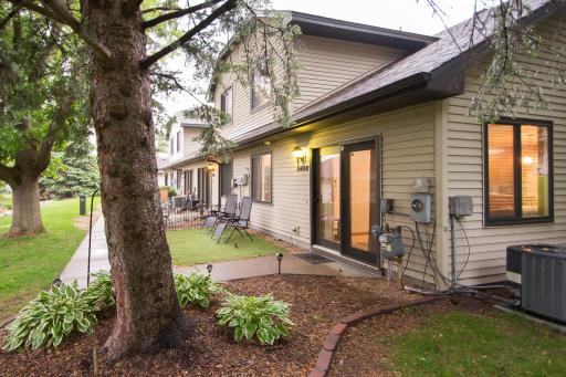 Tasteful landscaping with brick, mulch, mature trees, and perennials