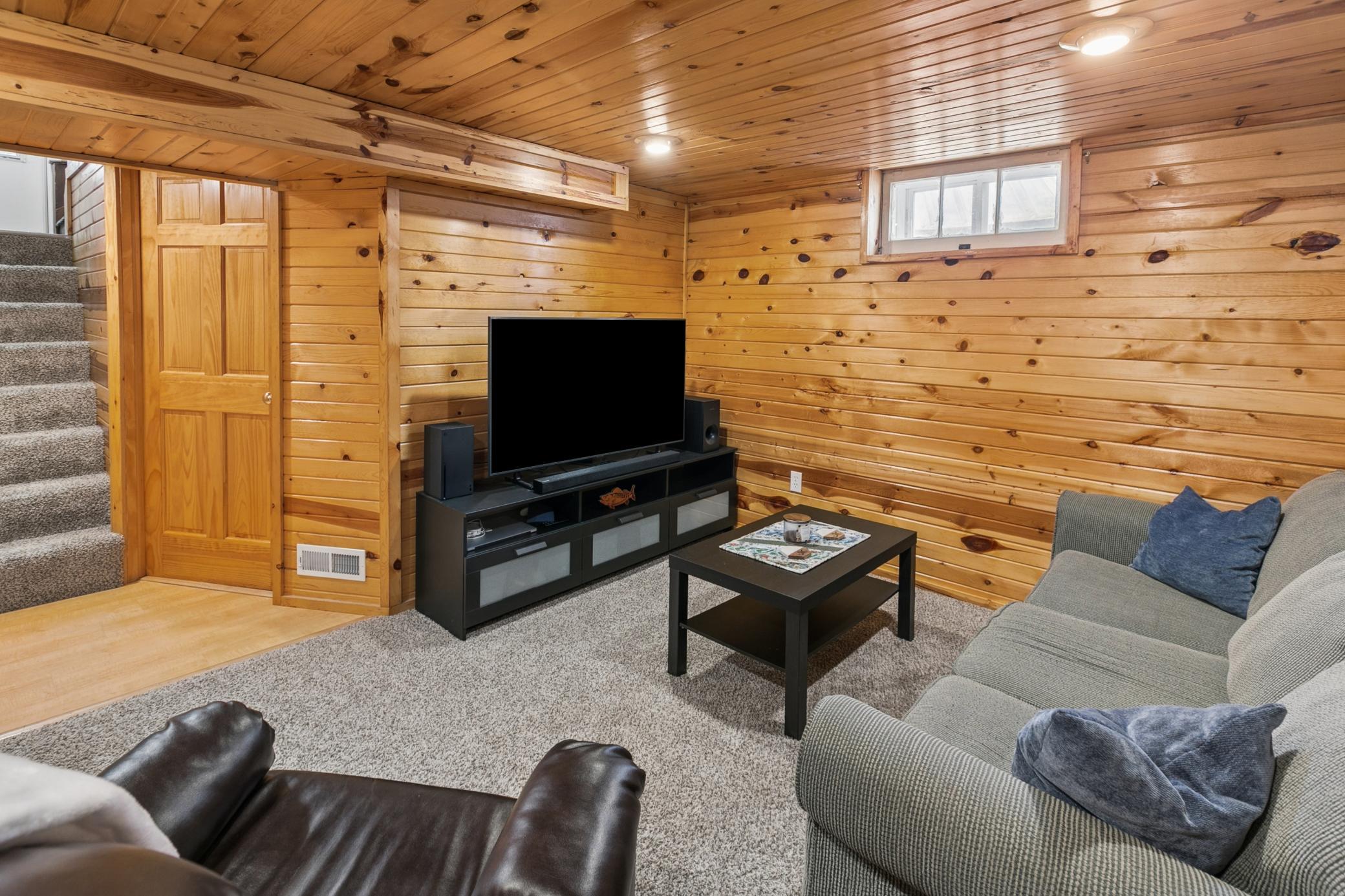 Lower level is finished with natural, knotty pine tongue and groove, solid paneled oak doors, and cozy carpet.