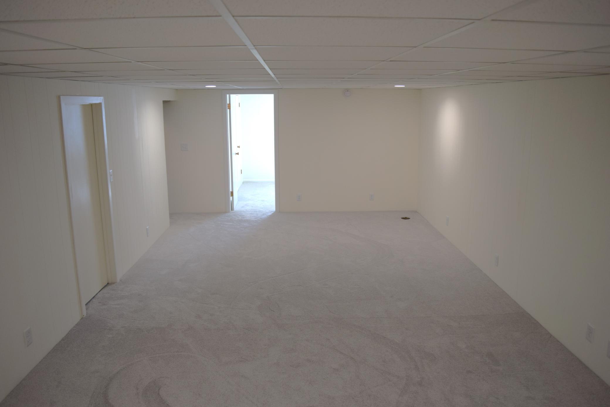 A view from the stairs overlooking the large 25 x 13 family room. The 4th bedroom is the door you see.