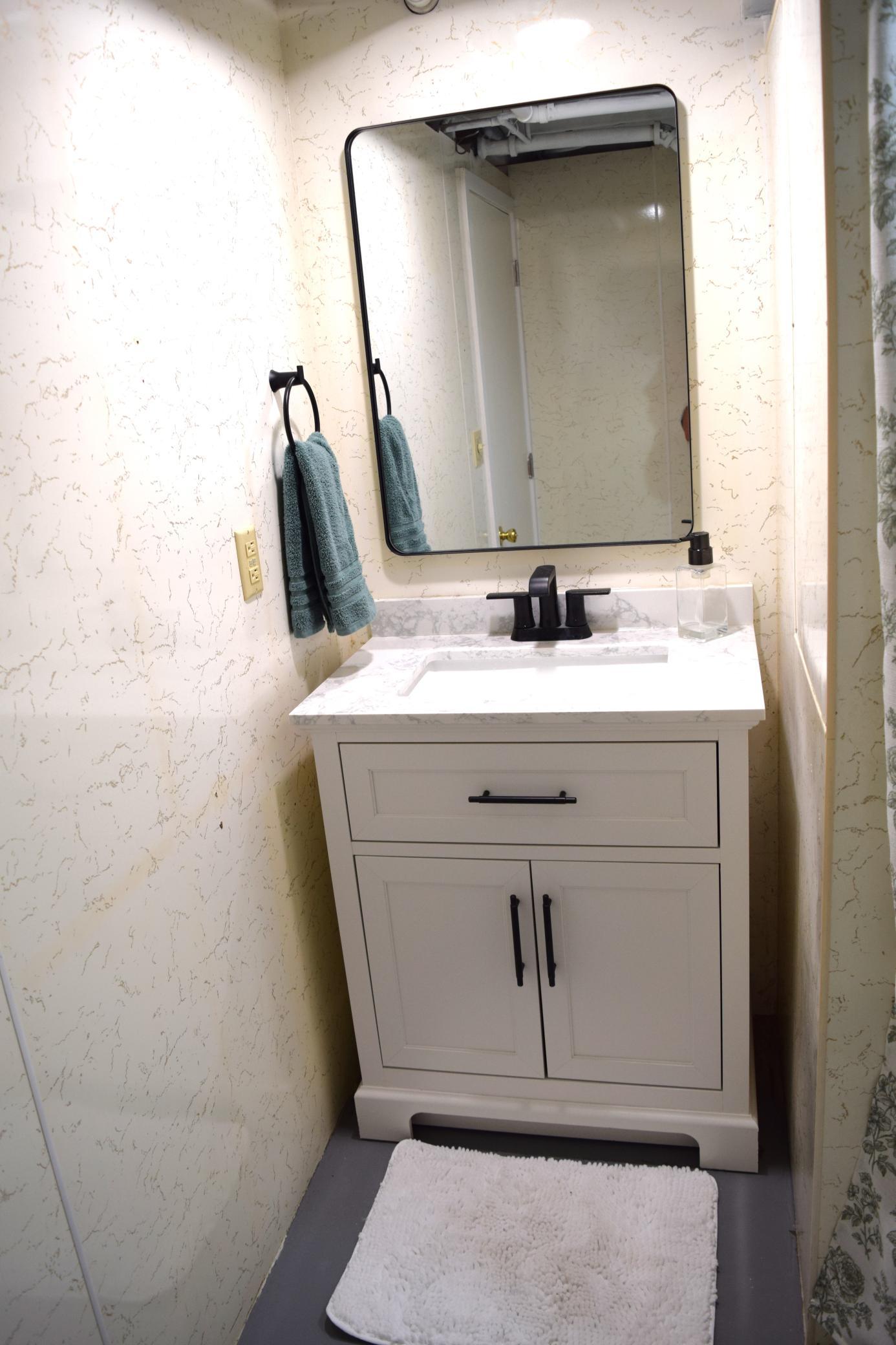 The lower level 3/4 bath has a brand new vanity and mirror combo and new toilet!