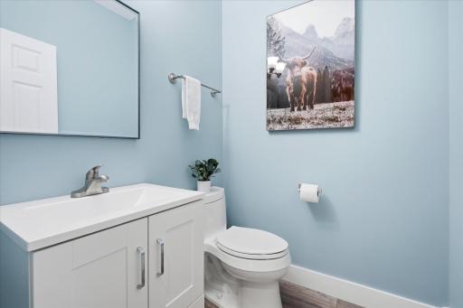 Cute half bathroom on the main level features an updated vanity and newer LVP flooring.