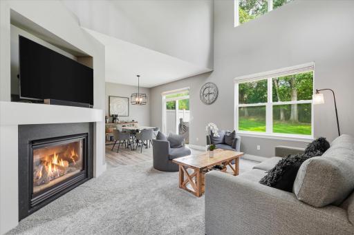 The living room features newer carpet and lots of large windows that bring in an abundance of wonderful natural light.