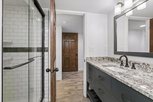 Lower level 3/4 bath with glass shower door and Subway tile.