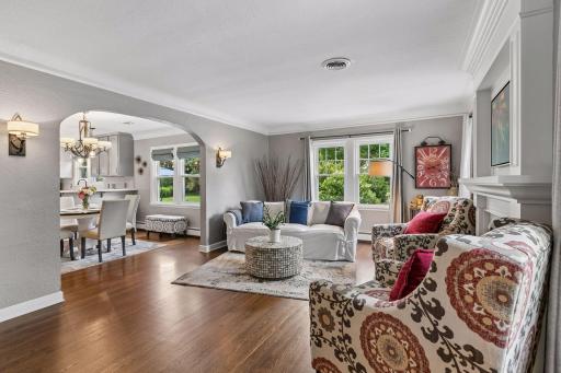 Coving, flat ceiling, hardwood floors, gas fireplace, newer windows in the open living room. Archways with sconce lighting lead to the dining room/kitchen.