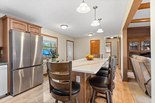 Gorgeous kitchen with natural woodwork, large quartz center island offers a spacious countertop and plenty of breakfast bar seating.