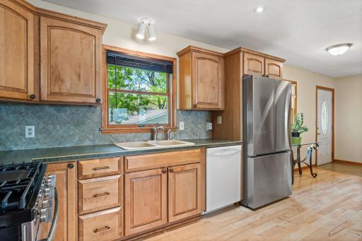 Beautiful maple, natural wood cabinetry, tiled backsplash and Stainless Steel appliances. Kitchen window brings an abundance of light and nature views inside.