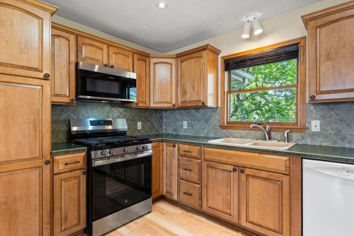 Beautiful maple, natural wood cabinetry, tiled backsplash and Stainless Steel appliances. Kitchen window brings an abundance of light and nature views inside.