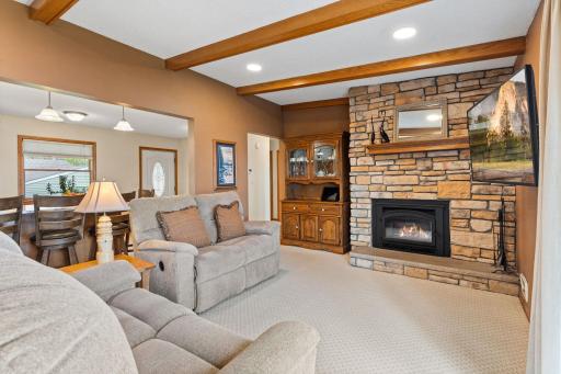 Cozy living room space highlight by elegant stone gas fireplaces. Beautiful wood beams accents the slightly vaulted ceilings.