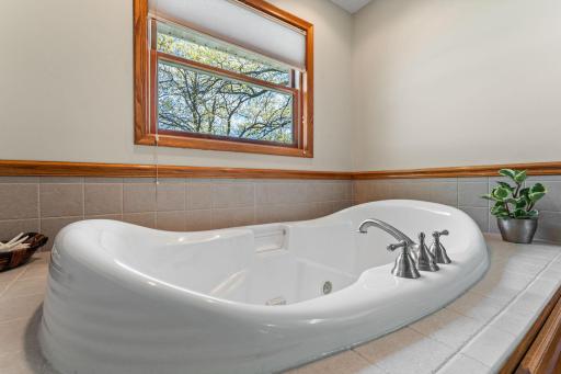 Relax after a busy day in this beautiful jacuzzi tub! Accented by gorgeous neutral tilework.