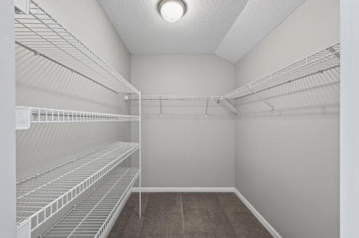 Large walk-in closet with extensive shelving and hanging space for effortless organization.