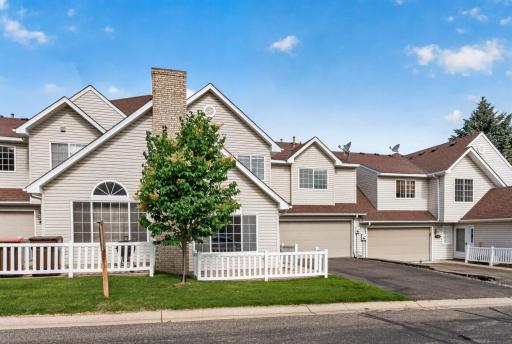 Welcoming front exterior featuring a private fenced patio and impressive arched windows.