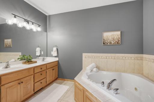 Primary bathroom with double sink vanity and a jetted soaking tub.