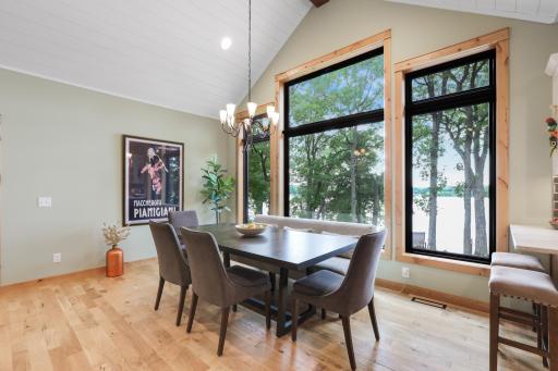 The dining area is surrounded by expansive Andersen windows that fill the space with natural light and showcase breathtaking panoramic lake views, creating an unforgettable setting for everyday meals and entertaining.