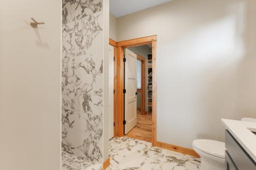 The primary bath features a beautifully tiled walk-in shower, offering a spa-like experience with modern finishes and thoughtful design.