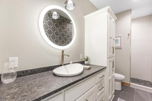 The second bathroom features tile flooring and a walk-in tiled shower, offering a clean, modern design with durable, easy-to-maintain finishes.