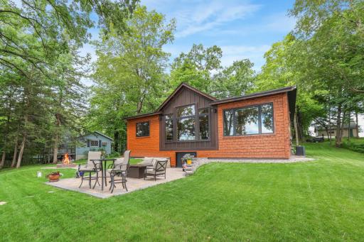 The lakeside showcases the beautiful pine siding, blending timeless craftsmanship with the natural beauty of the surrounding landscape.
