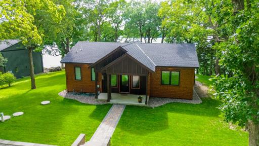 A birdâs-eye view reveals the cabin nestled among mature trees, with sweeping lake views that highlight the beauty and privacy of this exceptional setting.