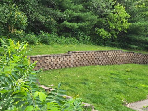 Beautiful private backyard with retaining wall and mature trees.