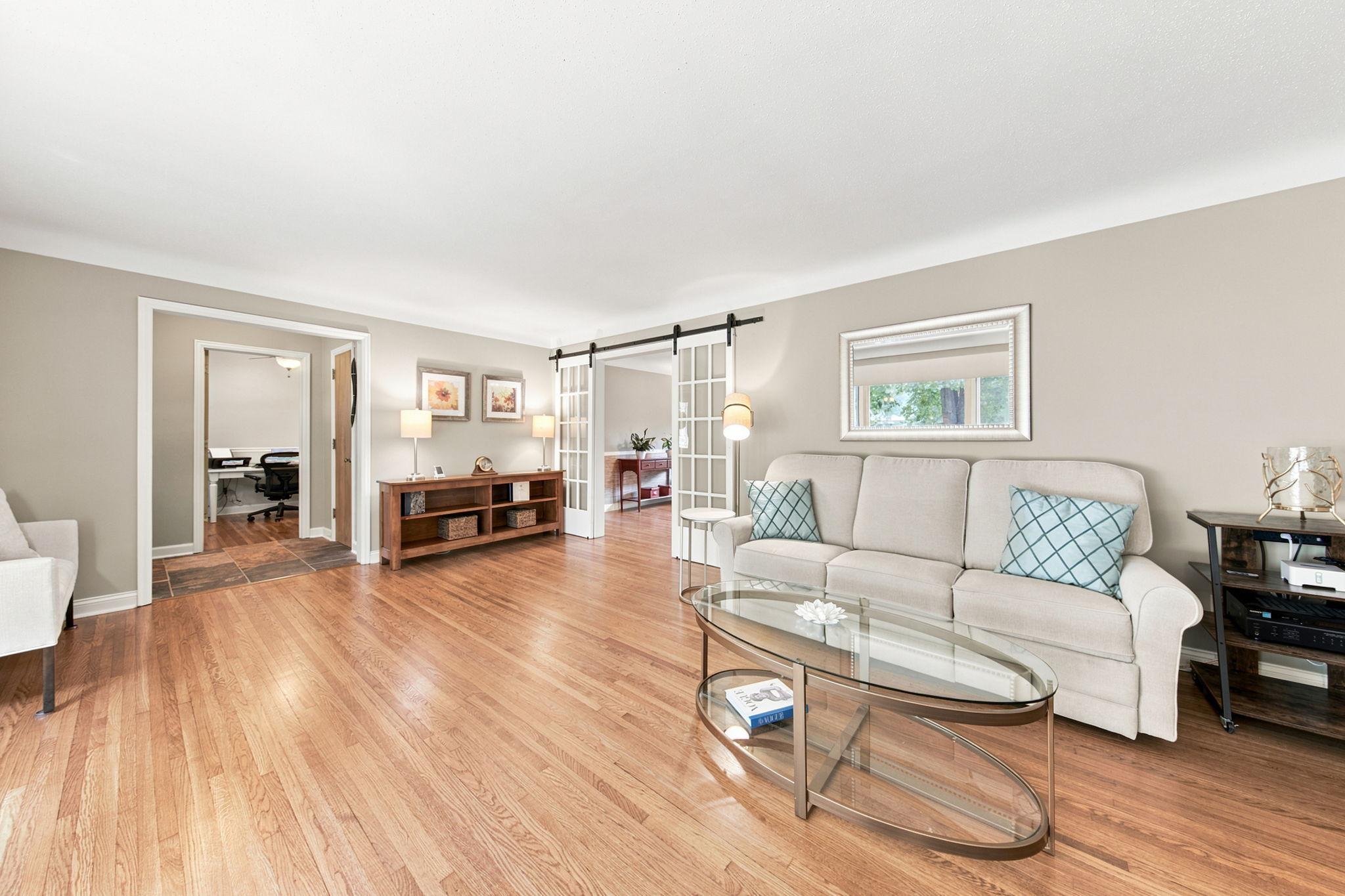 Another view of the spacious living area; sliding barn doors open to the inviting sitting room