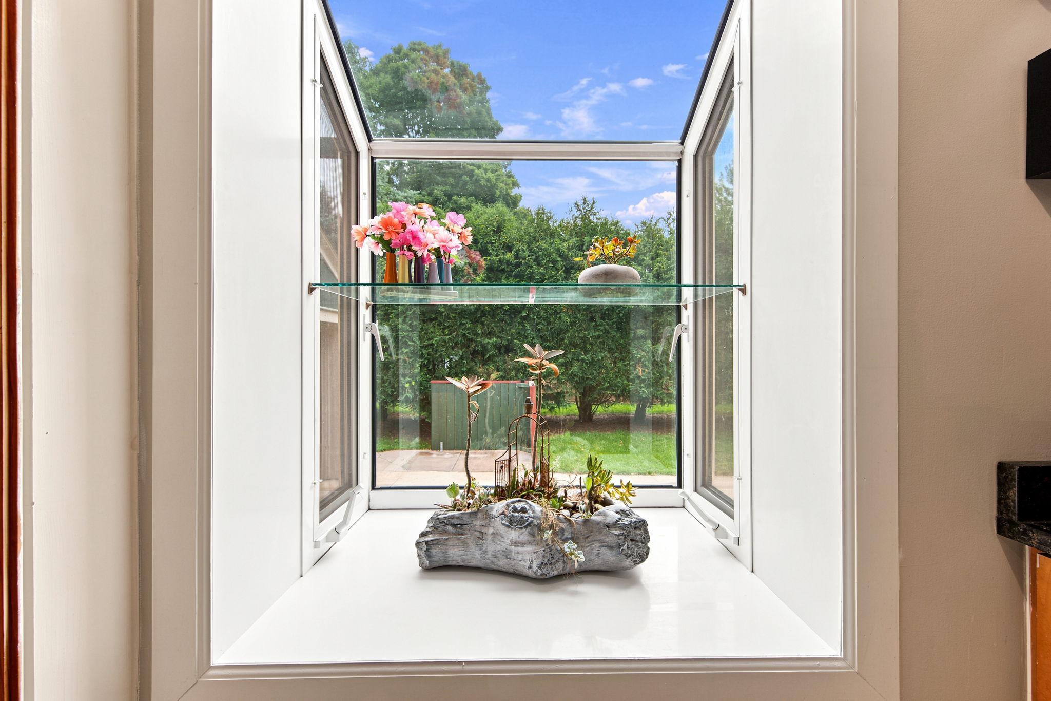 A lovely garden window adds natural light and character to the kitchen