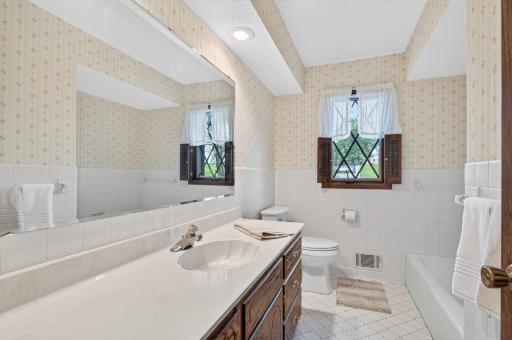 Large main floor bathroom features neutral tile on floor and walls.