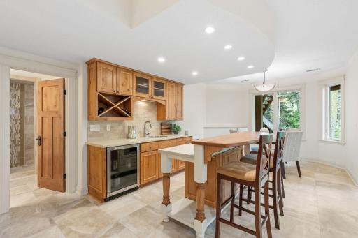 Wet bar with barstool seating, beverage fridge, microwave, and sink