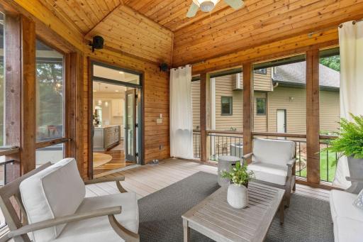 Charming screened porch with sweeping views of the yard and access to the deck
