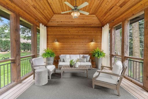 A true outdoor retreat, this spacious screened porch showcases a vaulted wood ceiling, floor to ceiling screens, ceiling fan, and serene backyard views