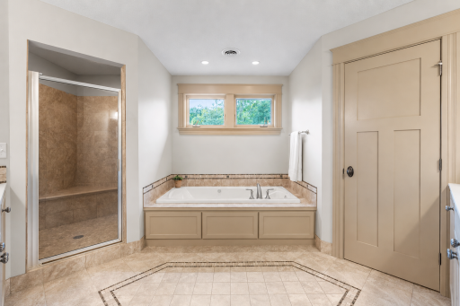 Primary bathroom with soaking tub, two closets, and double headed shower