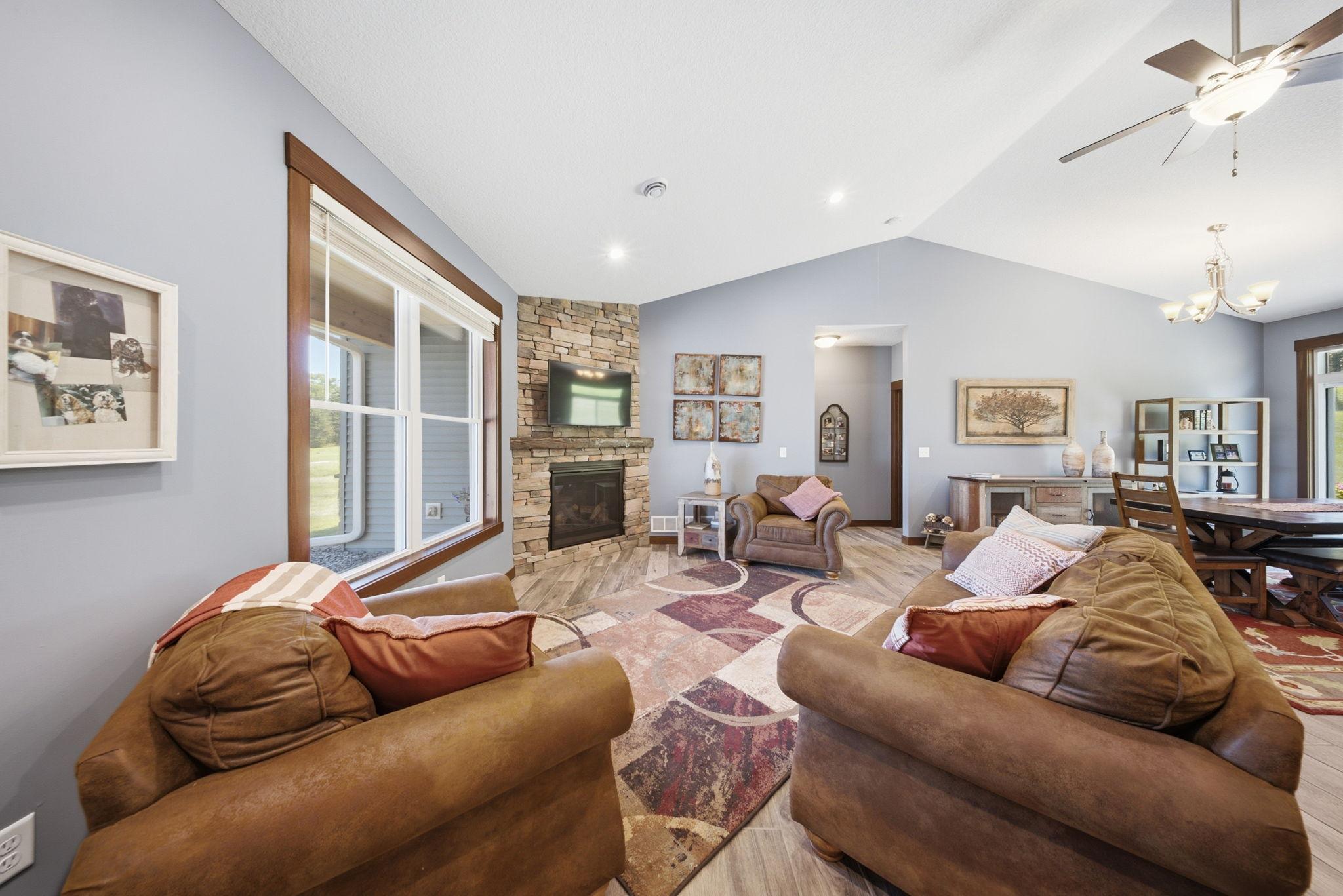 Inviting living room with expansive windows and views of the beautifully maintained yard.