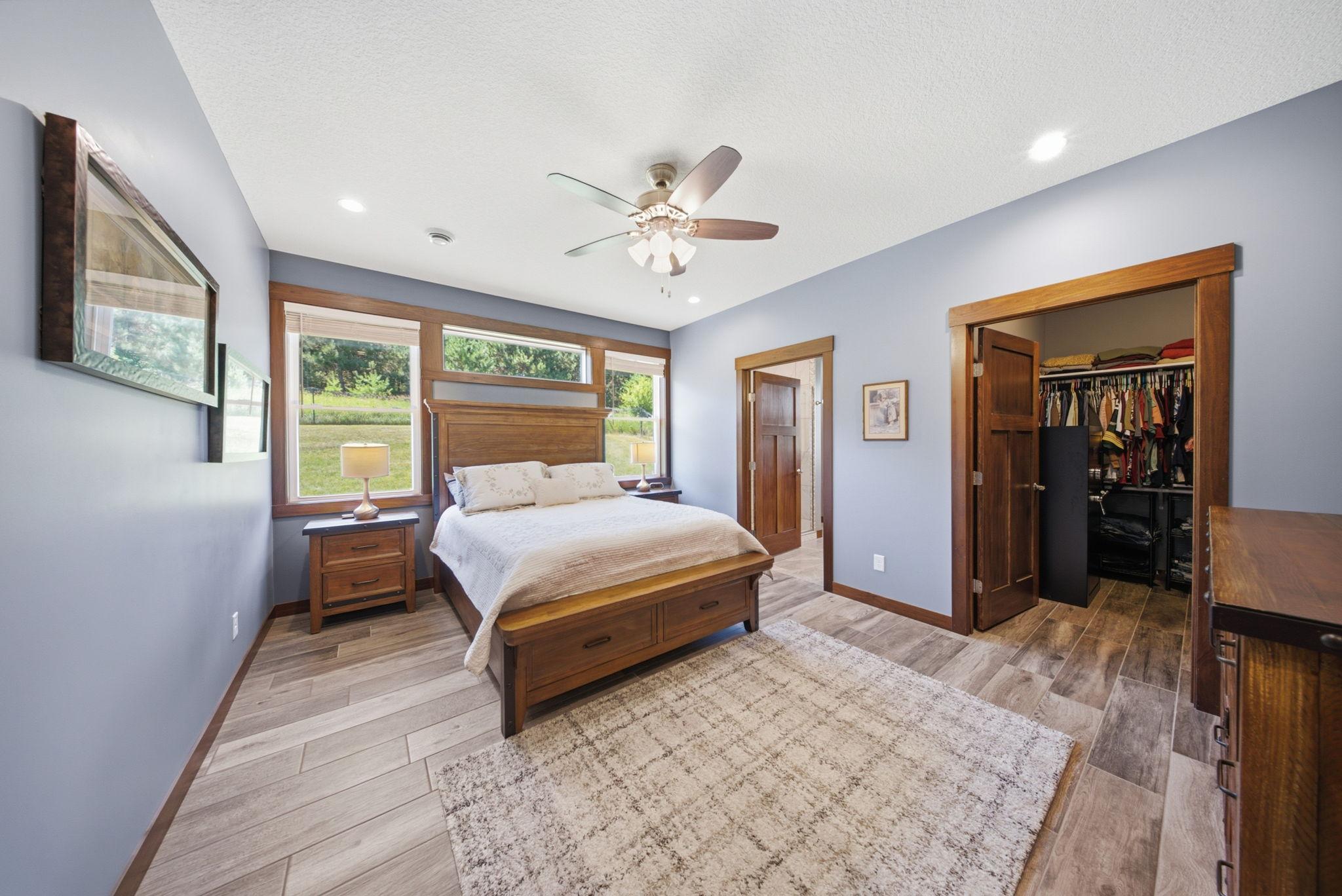 Spacious primary bedroom featuring large windows, walk-in closet, and private ensuite bath