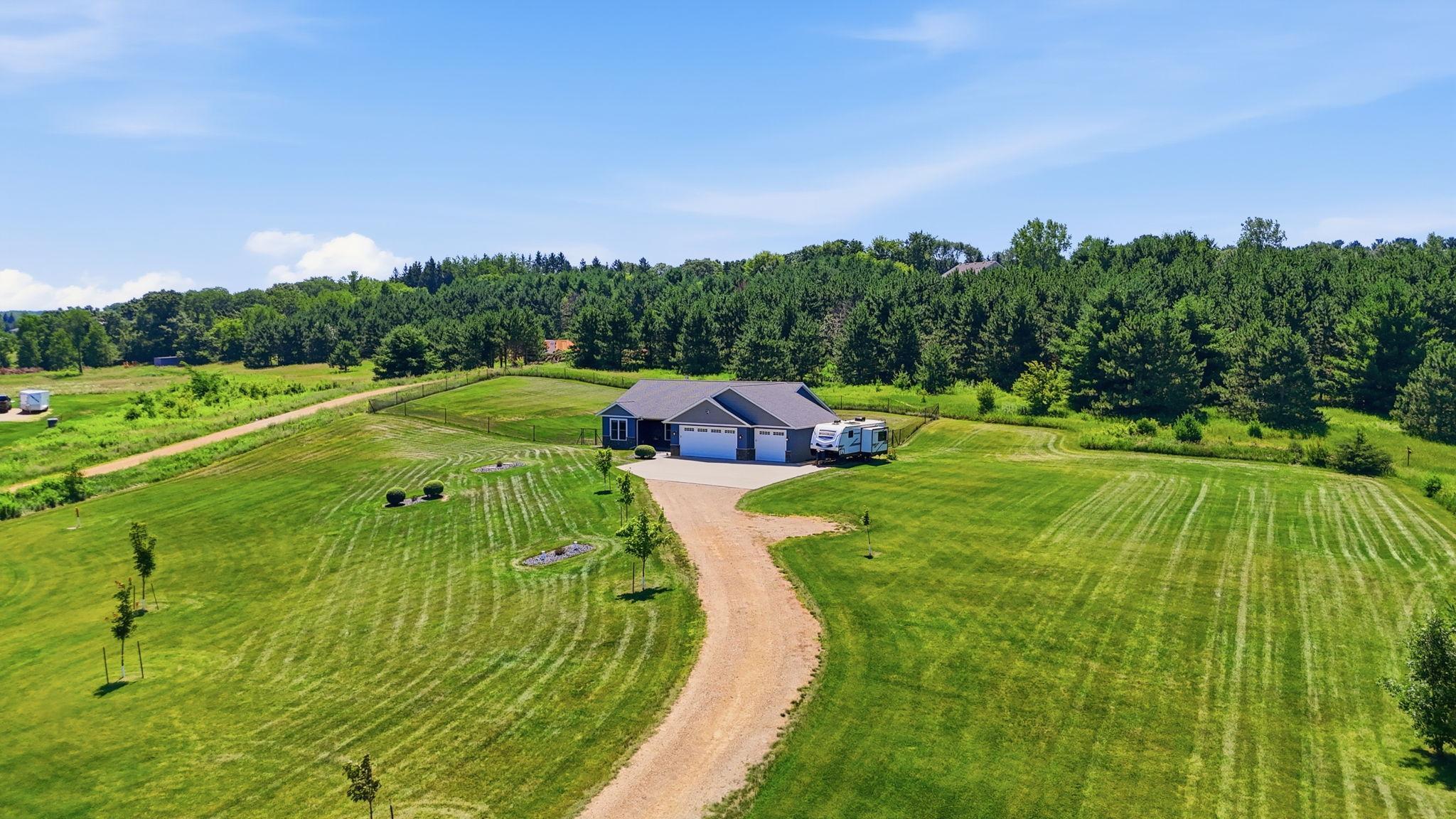 Long driveway, generous parking, and a beautifully landscaped setting create an impressive first impression.