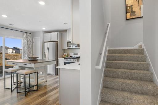 Transition from main floor to upper level via wide staircase. Photo is of model home. Colors and options may vary. Ask Sales Agent for details.