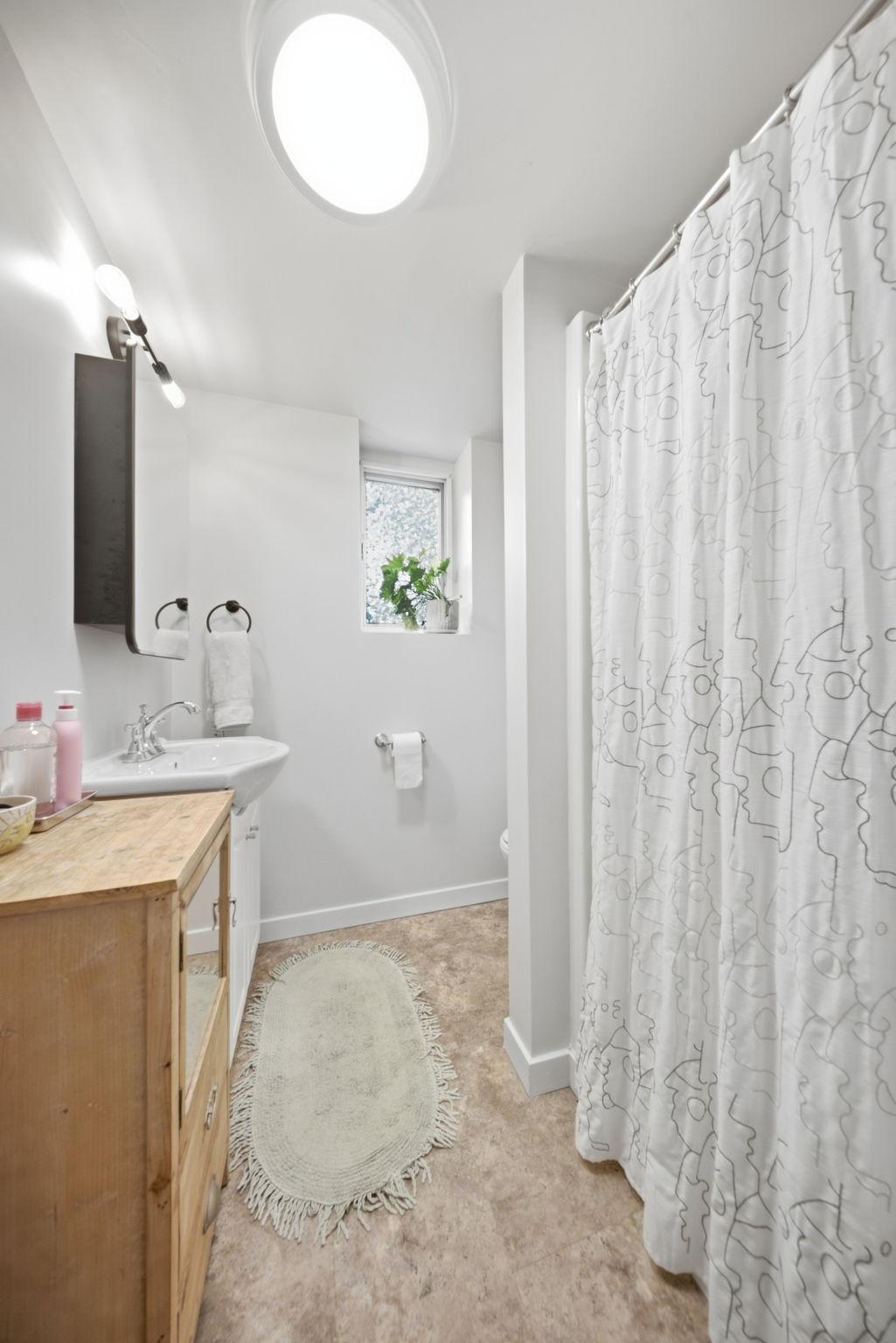 Convenient lower-level full bath with natural light and updated finishes.