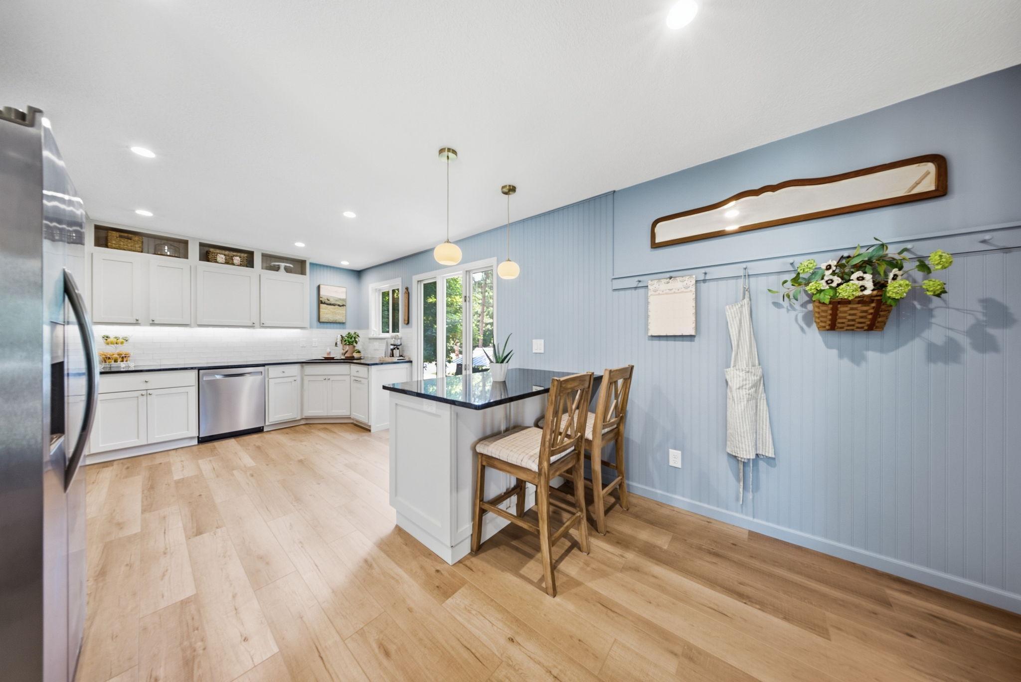 Kitchen with beadboard accent wall, peninsula seating, and generous workspace.