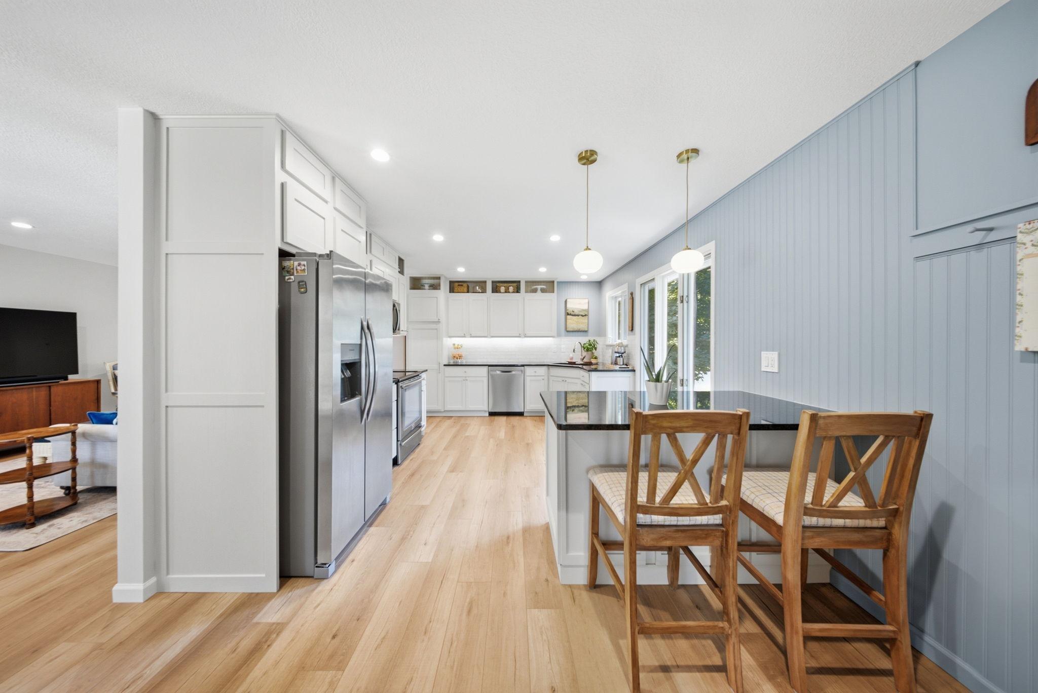 Beautifully updated kitchen featuring custom cabinetry, granite countertops, and breakfast bar.