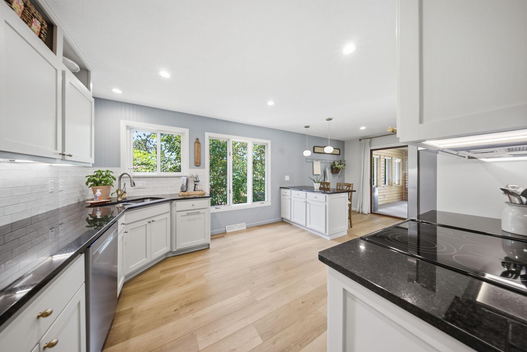 Large windows fill the kitchen with natural light while overlooking the backyard.